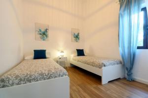 two beds in a room with blue curtains at Posada de la Judería II in Córdoba