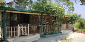 a house with a porch with a fence at EMERALD TRAIL BHIMTAL in Bhīm Tāl