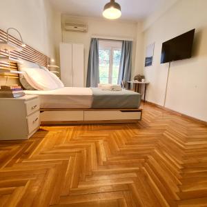 a bedroom with a bed and a wooden floor at Artistic Abode I Work-Friendly in Athens