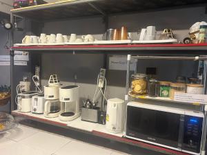 a shelf with a microwave and other appliances on it at Monkey Toe Guesthouse in Chiang Mai