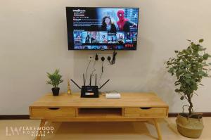 a tv hanging on a wall above a wooden desk at Lakewood Muji Style Neflix Water Dispenser Near Aeon in Kluang