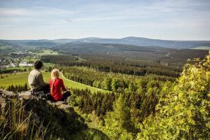 a man and woman sitting on a rock overlooking a valley at Zur Scheune - a88305 in Brand-Erbisdorf