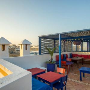 een patio met tafels en stoelen op een dak bij La Maison Du Vent in Essaouira