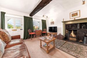 a living room with a couch and a fireplace at The Sheiling, Traditional Lakeland Cottage, Coniston in Coniston