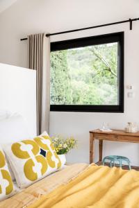 a bedroom with a window and a bed and a table at La Grange de Fer - Maison de caractère piscine privée in Saint-Ferréol-Trente-Pas