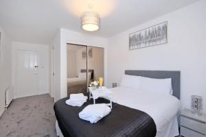 Un dormitorio con una cama y una mesa con toallas. en Orange Apartments Belgrave Mansions, en Aberdeen