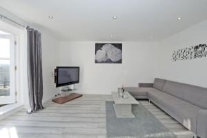 a living room with a couch and a tv at Orange Apartments Belgrave Mansions in Aberdeen