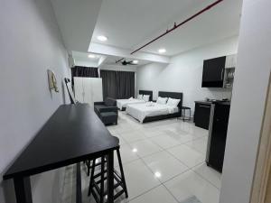 uma sala de estar com uma cama e um sofá e uma cozinha em De Centrum By Jom La Homestay, Kajang Bangi em Kajang