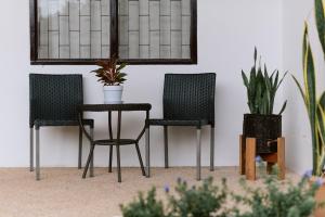 two chairs and a table in a room with plants at Homely Home Khao lak in Khao Lak