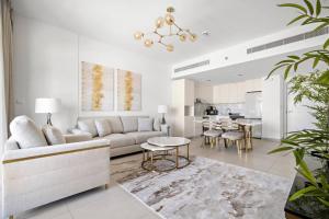 uma sala de estar com um sofá e uma mesa em Chic 1BR APT Rahaal 2 MJL em Dubai