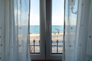 - une fenêtre avec vue sur la plage dans l'établissement La casa del mar by Gades Gestión, à Cadix