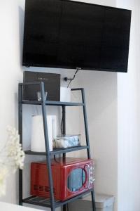 TV en un estante con microondas y TV en B&B Easy Apartment en Roma
