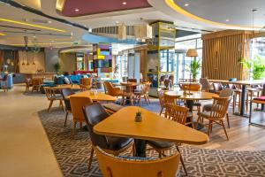 a restaurant with tables and chairs in a cafeteria at Hampton By Hilton Sakarya in Sakarya