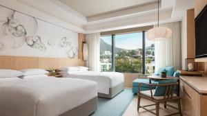 香港的住宿－香港海洋公園萬豪酒店，酒店客房配有两张床和一张桌子及椅子