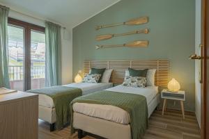 a bedroom with two beds and a balcony at Dolce Vita Family Apartment in Sirmione