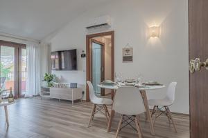 a dining room with a table and white chairs at Dolce Vita Family Apartment in Sirmione