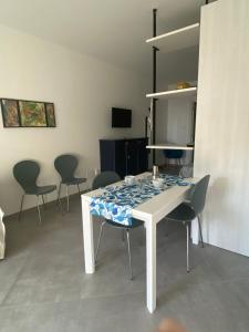 una sala da pranzo con tavolo e sedie bianchi di L'angolo di Anna a Noli