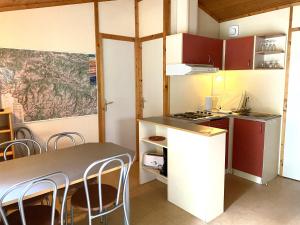 a kitchen with a table and chairs in a room at Chalets et Gites du Quié in Les Cabannes