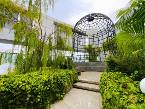 um jardim com gaiola para pássaros e algumas plantas em Trion Kuala Lumpur by Five Senses em Kuala Lumpur