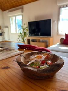 un plato de comida sentado en una mesa de madera en Logement avec vue panoramique à 10min des pistes en Sauto
