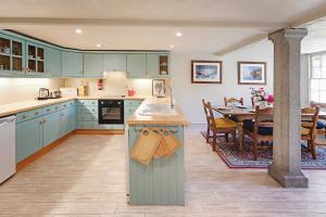 cocina con armarios azules y comedor con mesa en Eller How House - Private Regency Property & Lake, en Lindale