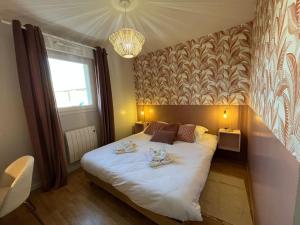 - une chambre avec un grand lit blanc et un lustre dans l'établissement Dahlia YourHostHelper, à Caen