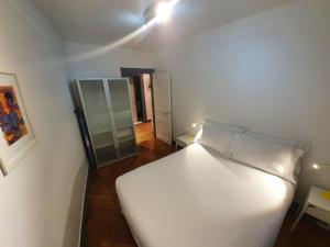 sypialnia z białym łóżkiem i lustrem w obiekcie Appartement Strasbourg Cathédrale w Strasburgu