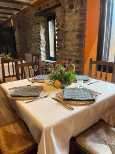 uma mesa com uma toalha de mesa branca e flores sobre ela em The Garden by LUKE em Ezcaray
