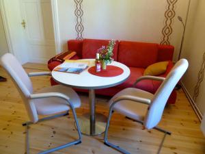 una mesa y sillas en una sala de estar con sofá en Ferienwohnung Villa am Haussee, en Feldberg