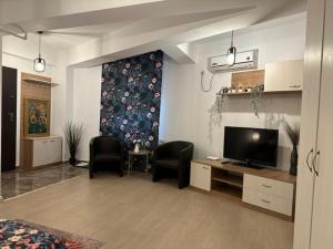 a living room with two chairs and a television at Central Studio Bucur in Bucharest