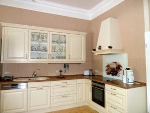 a kitchen with white cabinets and a sink at Ferienwohnung Villa am Haussee in Feldberg