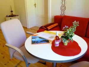 a white table with a book and flowers on it at Ferienwohnung Villa am Haussee in Feldberg