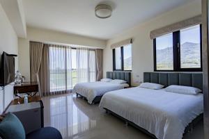 um quarto de hotel com duas camas e janelas em 漫步月眉民宿 em Guanshan