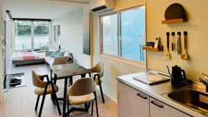 una cucina con tavolo e sedie e un soggiorno di 加美屋リゾート ひたち大洗オーシャンテラス-Kamiya Resort Hitachi Oarai Ocean Terrace a Nakaminato