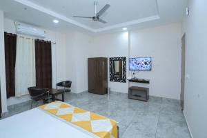 a bedroom with a bed and a desk and a tv at Raghav inn in Karnal
