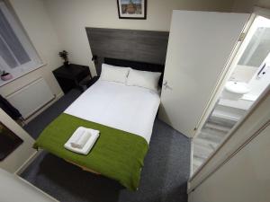 a small bedroom with a bed and a sink at Osney Juniper Studio - Self Contained Studio Flat in Oxford