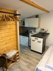a kitchen with white cabinets and a black counter top at Tiny Haus Glamping - Natur Park in Schlangenbad