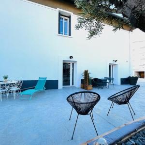 a patio with chairs and tables and a building at LE FIGUIER in Cabestany