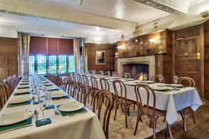 una sala conferenze con tavoli, sedie e camino di Caer Beris Manor By Group Retreats a Builth Wells