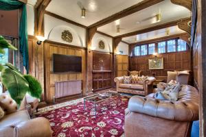 un soggiorno con divani e TV a schermo piatto di Caer Beris Manor By Group Retreats a Builth Wells