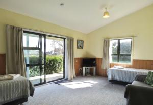 a hotel room with a bed and a large window at Mystery Creek Motel in Hamilton