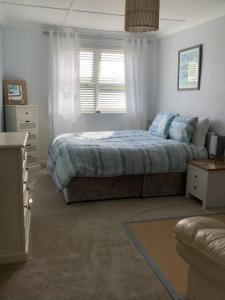 a bedroom with a bed and a window at Awel Y Mor - cosy apartment. in Verwick