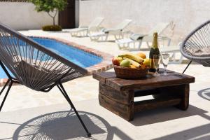 uma cesta de frutas sobre uma mesa ao lado de uma piscina em Villa Palace em Donji Zemunik