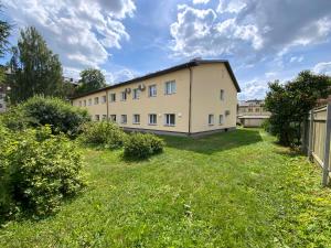 a building with a grassy yard in front of it at Vanemuise apartment in Tartu