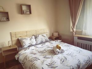 a bedroom with a bed with two stuffed animals on it at Cozy Trg in Lazarevac
