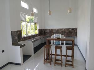 a kitchen with a counter and a table and stools at Kurumba Holidays Srilanka in Galle