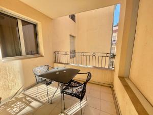 a balcony with a table and two chairs on it at Le Vieux Port Apartments in Cannes