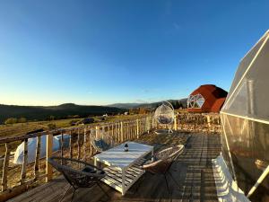 Dorna Iglu Luxury Glamping Resort في Dorna Cîndrenilor: طاولة وكراسي على سطح قارب