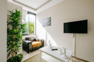 a living room with a couch and a tv at Chic Flat w Garden Nature View in Kemer in Antalya