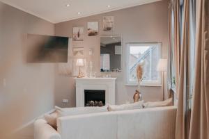 a living room with a white couch and a fireplace at Cottage an der Elbe Tespe Hamburg in Tespe